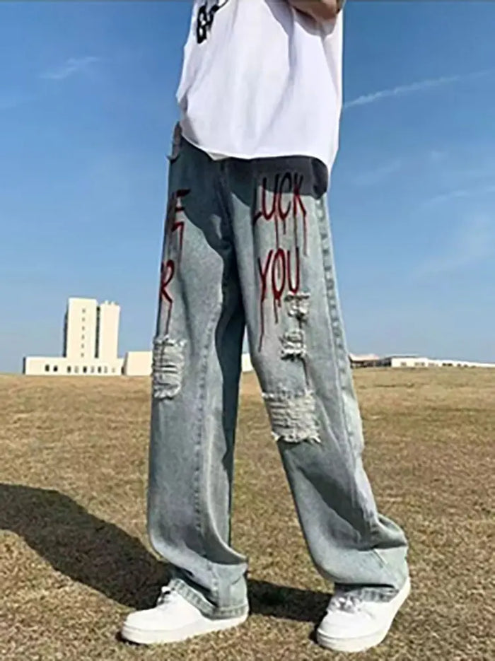 Jean droit vintage pour homme, style streetwear Y2K, coupe large et baggy, avec imprimés et effets déchirés.